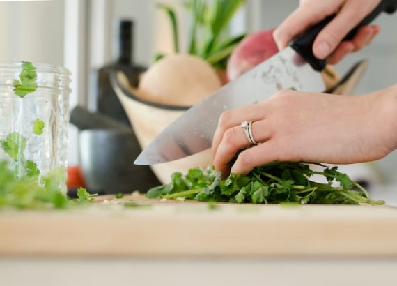 A photo of a chef cutting parsley leaves in her kitchen is one of the most profitable online business ideas